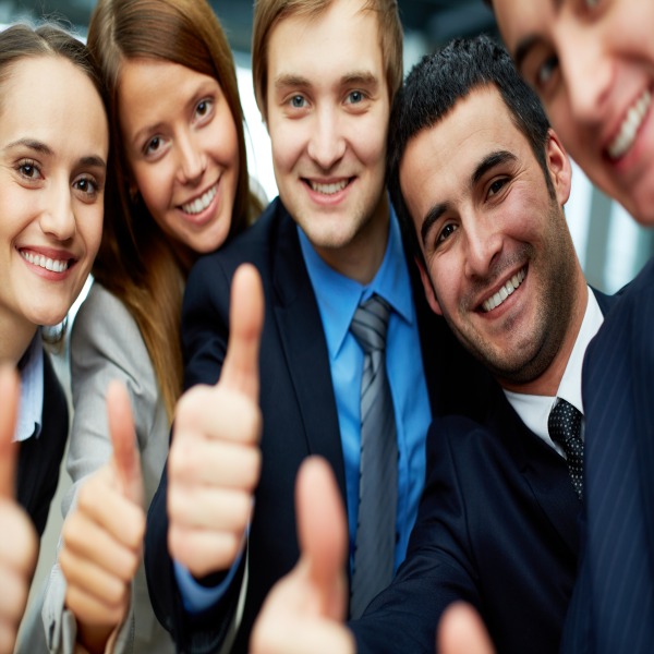 Portrait of five business partners keeping thumbs up and looking at camera with smiles